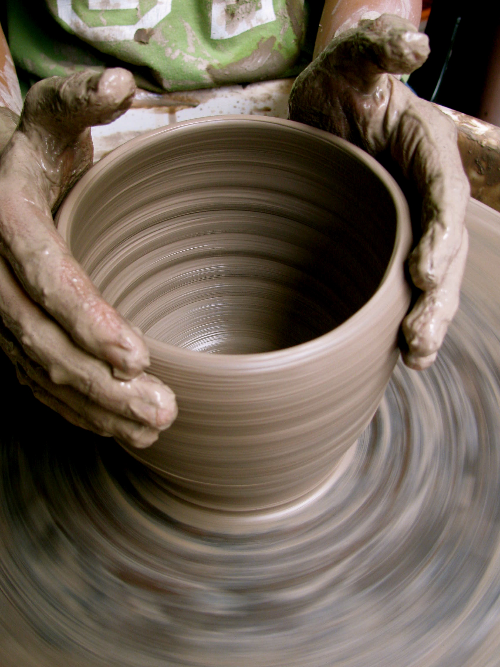 Hands working on a piece of pottery