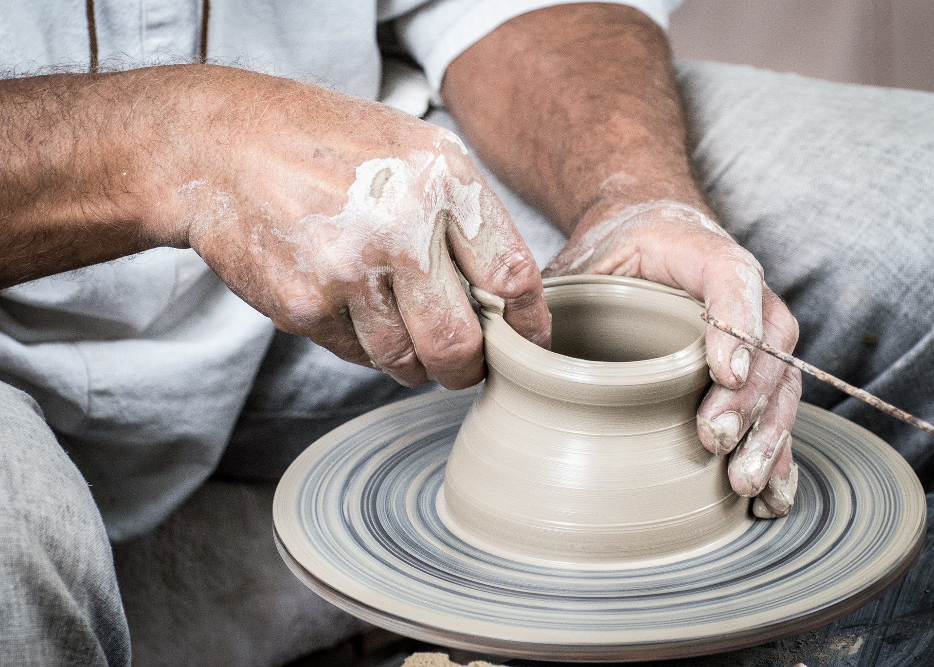 adult making pottery