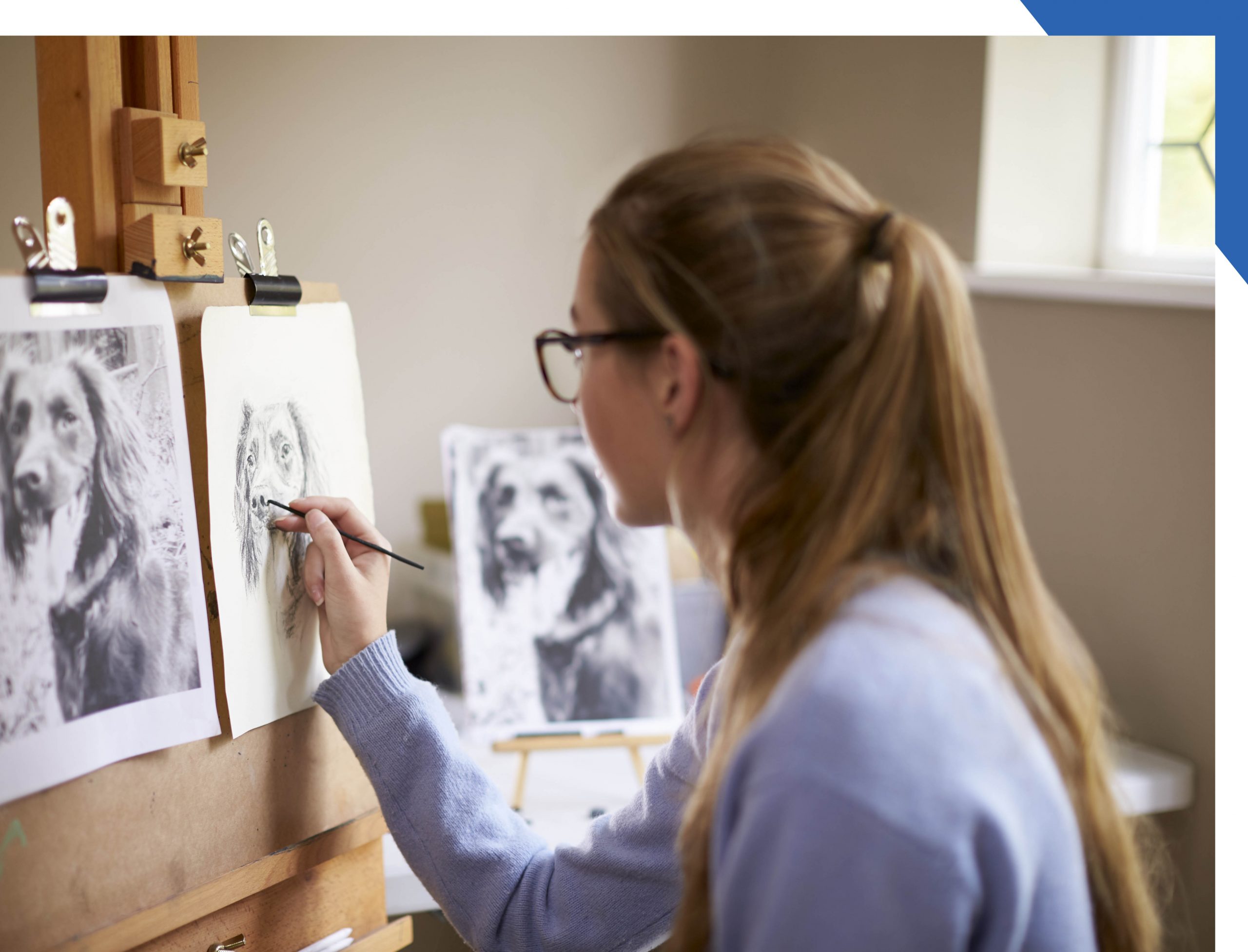 Woman drawing from a picture of a dog
