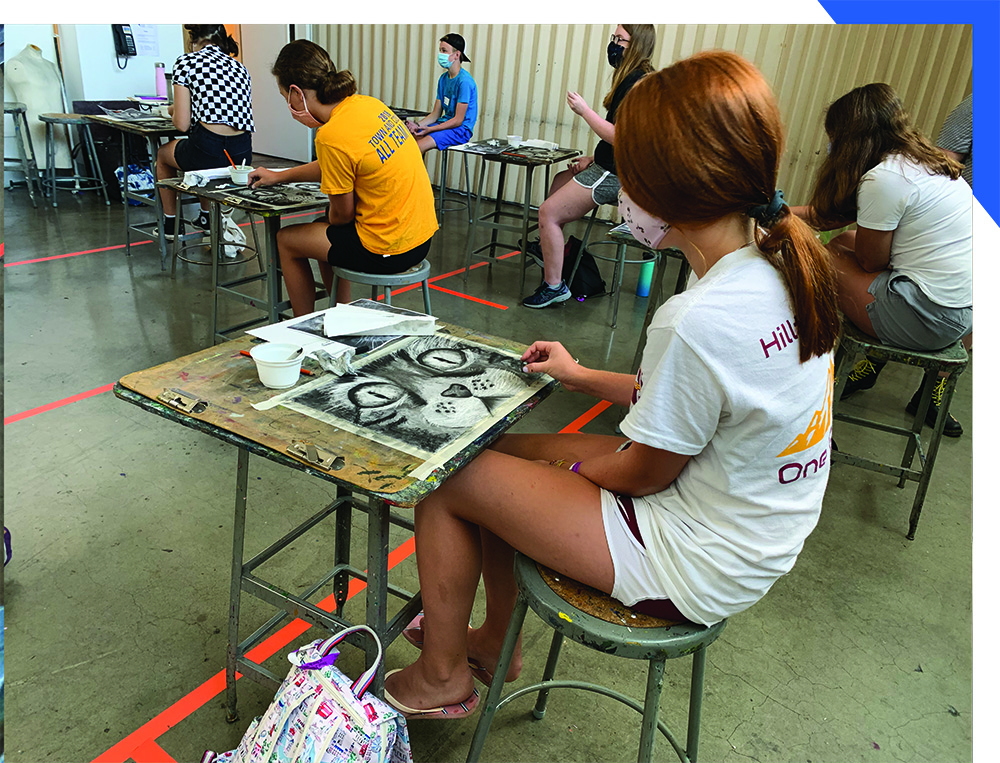 masked female student drawing in studio