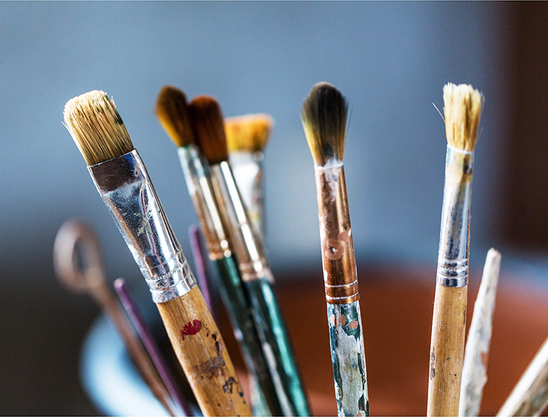 Artist paint brushes in a cup.