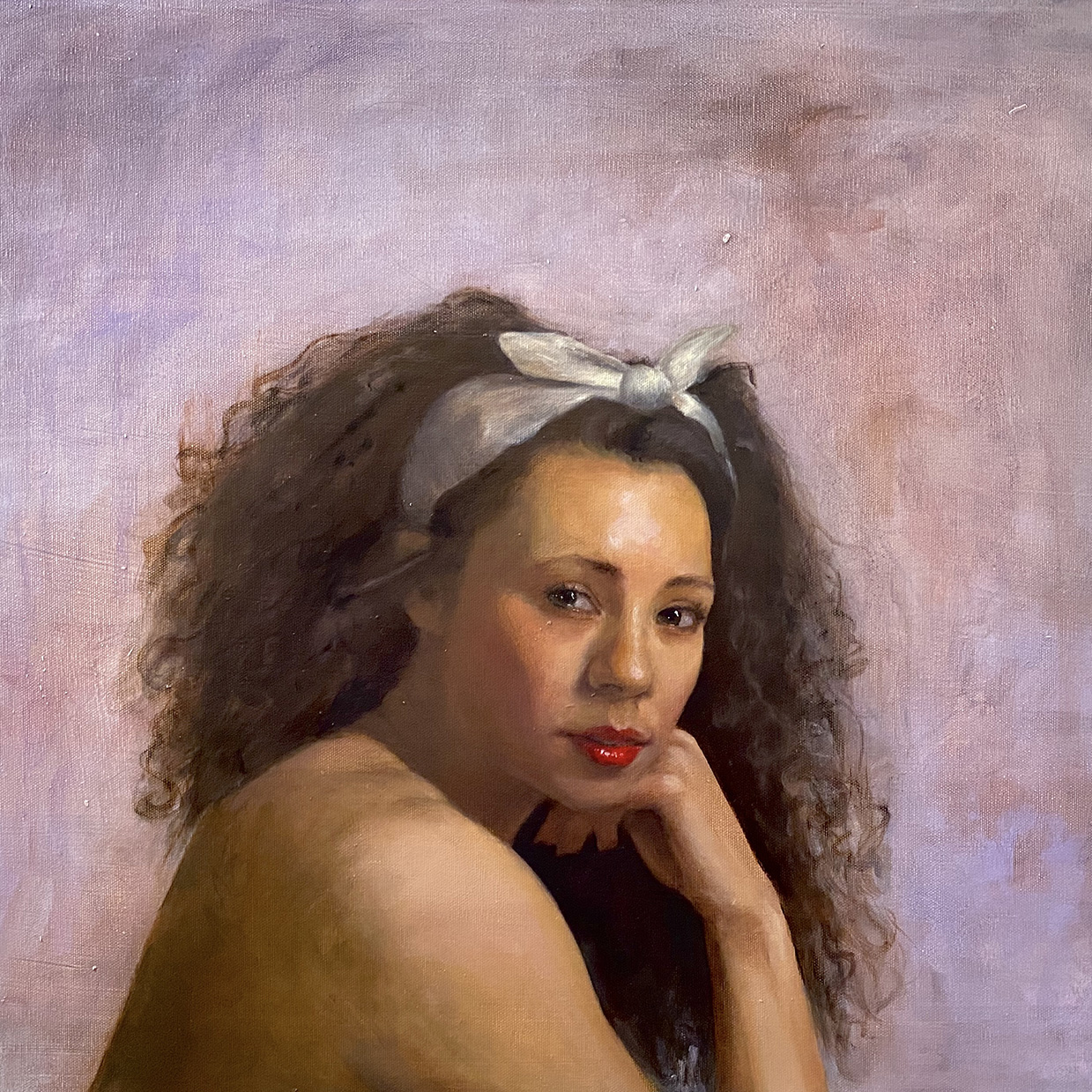 Celeste Maslovsky Flora, 2022 Oil on canvas 20 x 24 inches. It is a realistic photo of a woman with brown skin, red lips, black eyes, and curly brown hair tied up with a white ribbon.