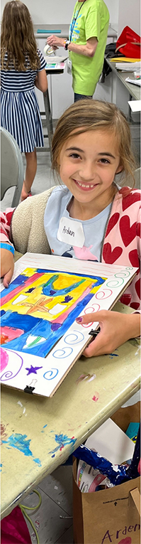 A child artist showing her work.