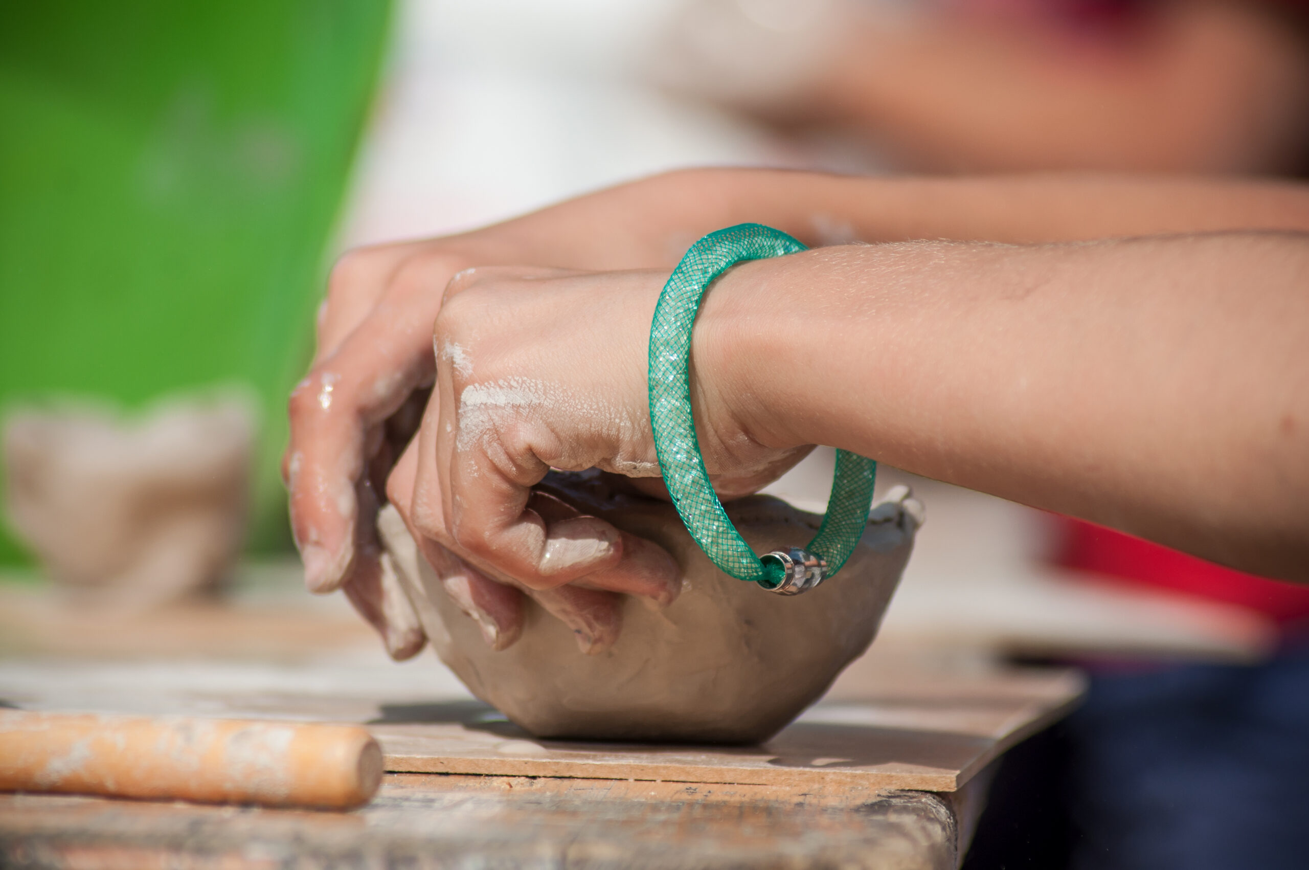 closeup of hands of child making clay pottery bowl in outdoor Artist taking an online art class